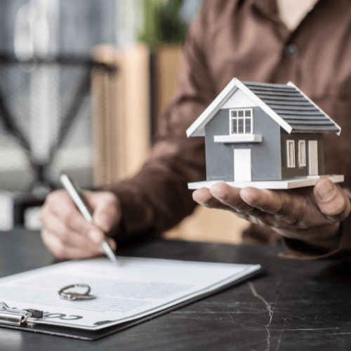 Man holding a house on his hand